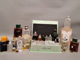 many bottles of perfume on a table with a picture frame