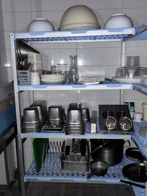 de nombreuses casseroles et poêles sur les étagères de la cuisine