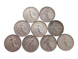 a close up of a pile of silver coins on a white surface