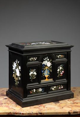 une image représentant une boîte en bois noire ornée de fleurs