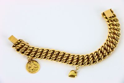 a close up of a gold bracelet with a coin on it
