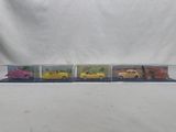 four toy cars are lined up in a row on a white background