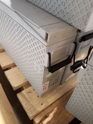 un réfrigérateur blanc posé sur une palette
