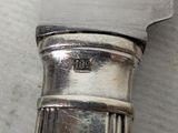 a silver knife that is laying on a table