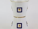 deux tasses blanches ornées de motifs bleus et dorés, posées sur un fond blanc