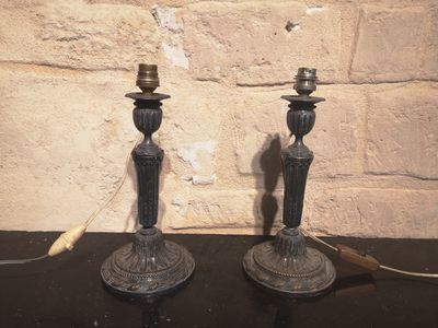 deux bougies posées sur une table près d'un mur de briques