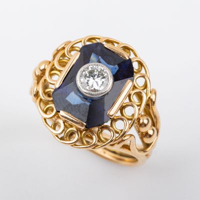 une photo d'une bague en or sertie d'une pierre bleue et d'un diamant