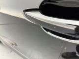 a close up of a car door handle with a person standing next to it