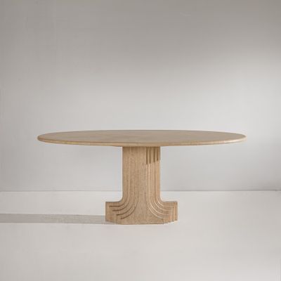 une table à manger ronde avec un piètement en bois dans une pièce blanche