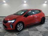 une voiture rouge est garée sur le sol en damier d'un garage