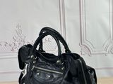 black leather handbag sitting on a wooden table in front of a wall