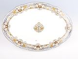 un plat ovale orné d'un motif doré et blanc