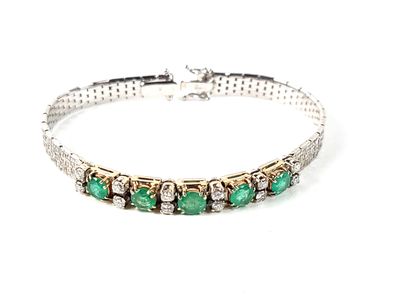 un gros plan d'un bracelet orné de pierres vertes sur fond blanc