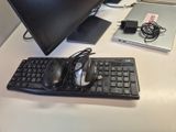 un clavier, une souris et un écran posés sur un bureau