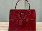 a red purse sitting on top of a wooden table