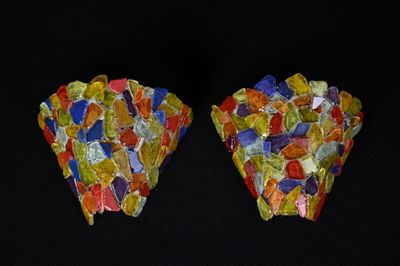pair of multicolored rocks on a black surface with a black background