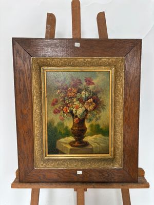 un tableau représentant des fleurs dans un vase, posé sur un chevalet