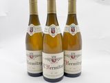 trois bouteilles de vin posées sur une table blanche