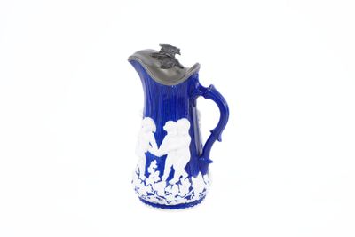 a blue and white pitcher with a silhouette of a man and a woman on it
