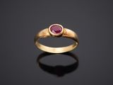 une bague en or avec un rubis au centre