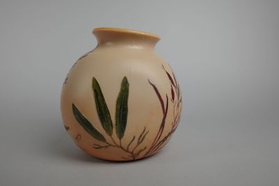 un petit vase avec une plante dessus, posé sur une table