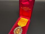 medal in a red case on a black surface with a gold ribbon