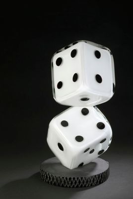 two white dice stacked on top of each other on a black surface