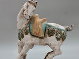 statue d'un cheval avec une selle sur le dos