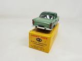 green toy car sitting on top of a yellow box on a white surface