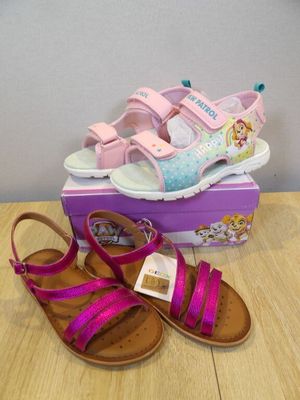 two pairs of girls ' sandals are sitting on a table