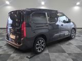 the back of a black van is parked on a checkered floor