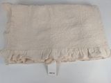 an image of a white pillow with ruffled edges on a white surface