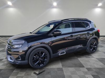 Une Citroën noire de 2020 est garée dans une pièce au sol carrelé en damier