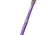 un aspirateur violet et argenté est posé sur une surface blanche
