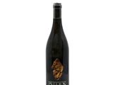 a bottle of wine sitting on top of a white surface