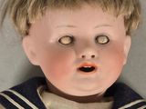 a close up of a doll wearing a sailor ' s outfit