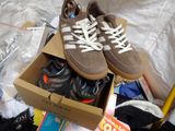 two pairs of shoes in a cardboard box on a bed
