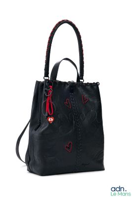 un sac à main noir orné d'un cœur rouge sur le côté