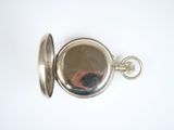 a silver pocket watch on a white surface