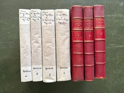 trois livres rouges et blancs posés sur une table verte