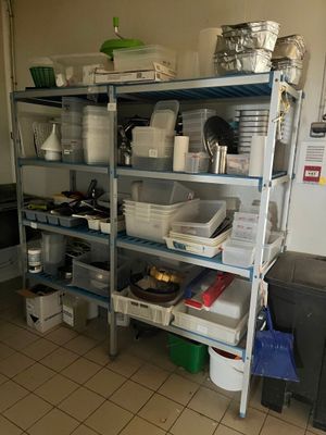 une cuisine avec une étagère remplie de casseroles et de poêles