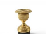 a gold vase with a black base on a white background