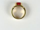 an image of a gold ring with a red stone