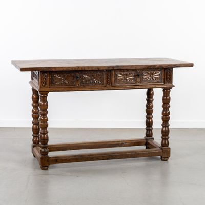 une vieille table en bois surmontée de deux tiroirs