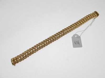 a close up of a gold chain bracelet with a tag on it