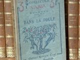 un livre posé sur une étagère, devant une pile de livres