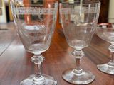 three empty wine glasses sitting on a wooden table in a room
