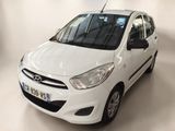 the small white car is parked in a white room