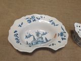 a blue and white bowl and a candle holder on a table