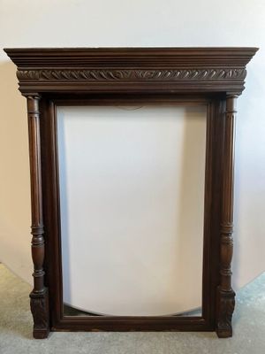 an old wooden fireplace mantle with a white wall in the background